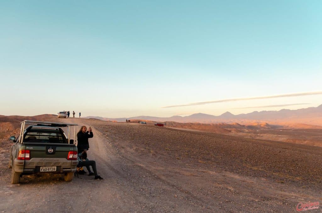 Vans e carro de passeio no normal em um mirante no Atacama